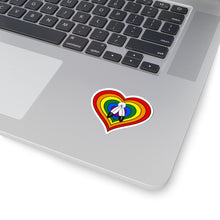 Close-up of the bottom right corner of a silver laptop featuring a 2 inch by 2 inch pride flag heart sticker in a Two-Spirit flag style applied to the surface.