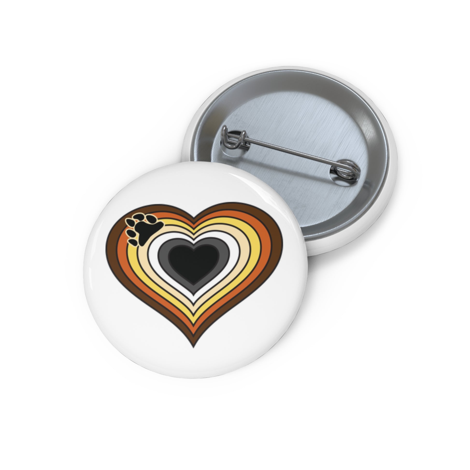 Front and back view of a circular pride button featuring a nested heart design inspired by the bear pride flag in brown, orange, yellow, cream, white, gray and black with a black bear paw print on the left side of the image. The design has a thin black border, and the button is shown on a white background.