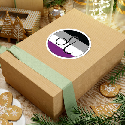 Gift box with a green ribbon on a festive background with cookies and Christmas decorations. Leo Asexual pride sticker centered on the box.