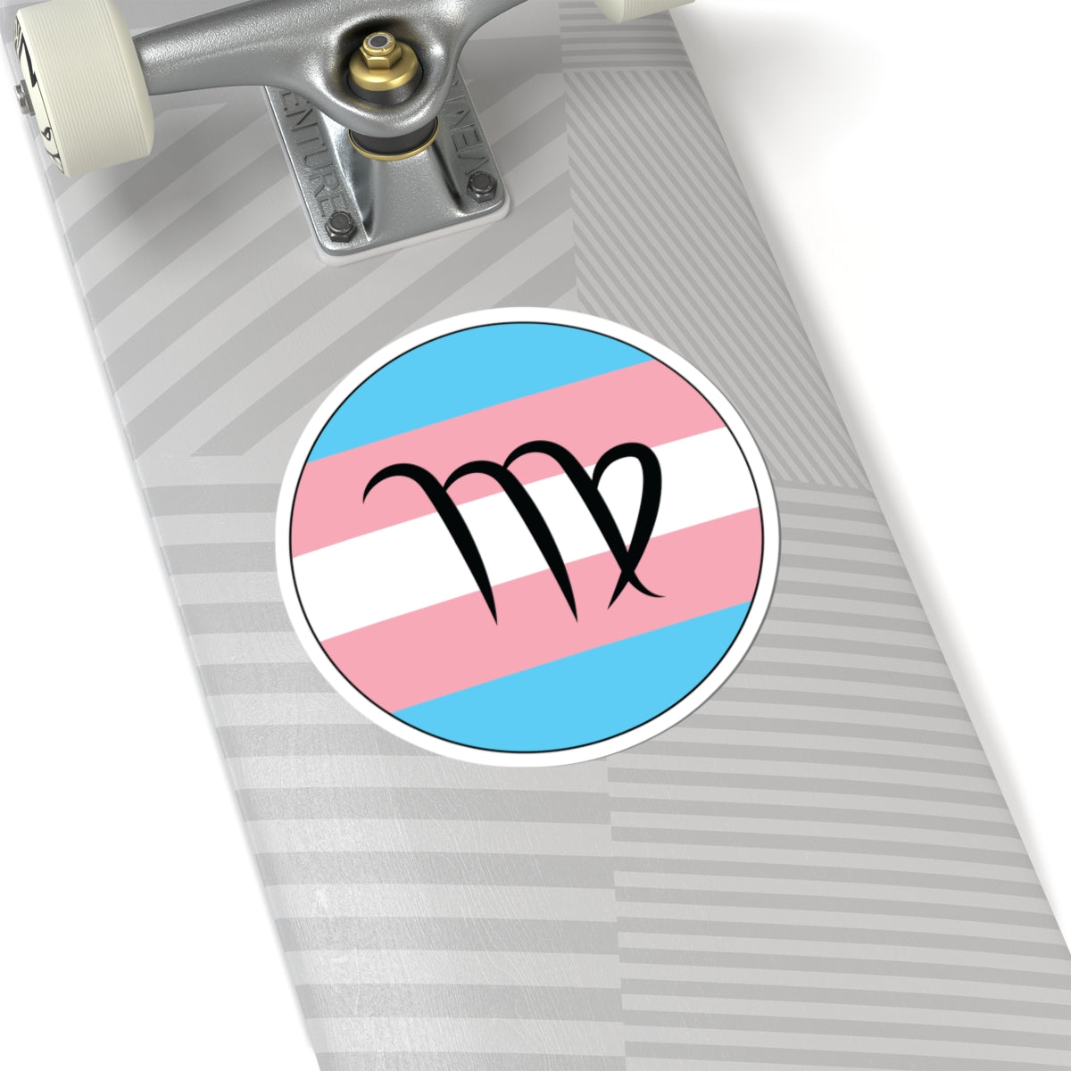 Close-up of the bottom right corner of a silver laptop featuring a 6 inch by 6 inch circular zodiac sticker with a centered Virgo glyph on a Transgender pride flag style background applied to the surface.