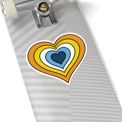 Close-up of the bottom of a silver skateboard featuring a 6 inch by 6 inch pride flag heart sticker in an Aroace flag style applied to the surface.