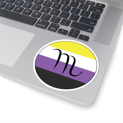 Close-up of the bottom right corner of a silver laptop featuring a 4 inch by 4 inch circular zodiac sticker with a centered Scorpio glyph on an Nonbinary pride flag style background applied to the surface.