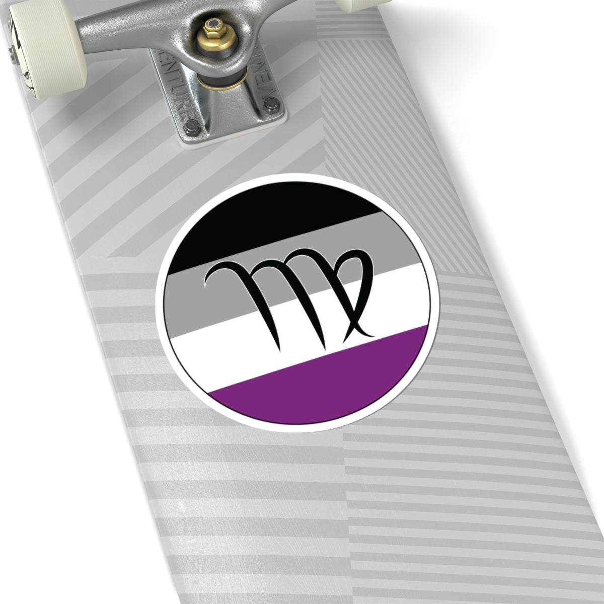 Close-up of the bottom of a silver skateboard featuring a 6 inch by 6 inch circular zodiac sticker with a centered Virgo glyph on an Asexual pride flag style background applied to the surface.