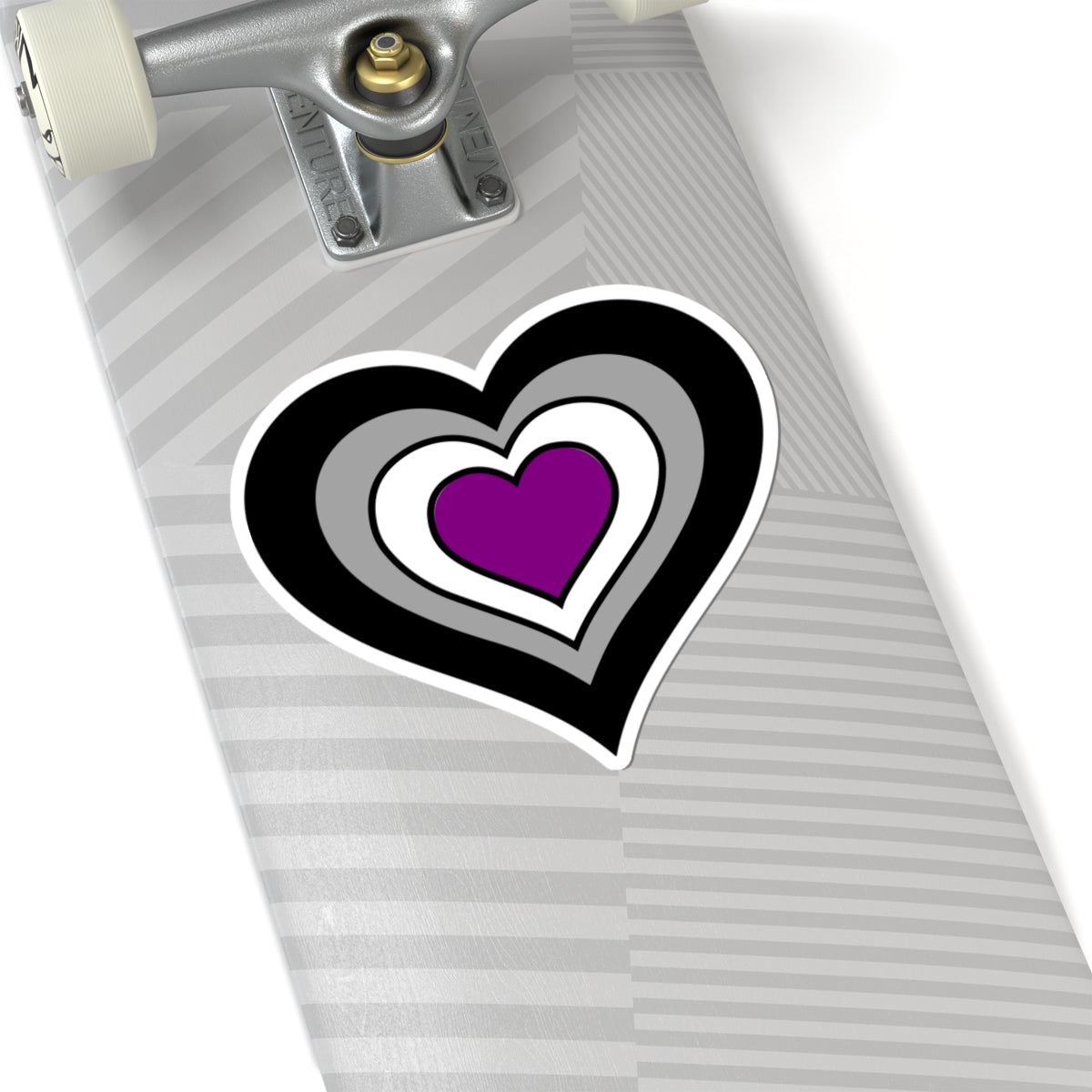 Close-up of the bottom of a silver skateboard featuring a 6 inch by 6 inch pride flag heart sticker in an Asexual flag style applied to the surface.