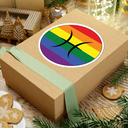 Gift box with a green ribbon on a festive background with cookies and Christmas decorations. Pisces Rainbow pride sticker centered on the box.