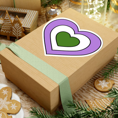 Gift box with a green ribbon on a festive background with cookies and Christmas decorations. Heart-shaped Genderqueer pride sticker centered on the box.