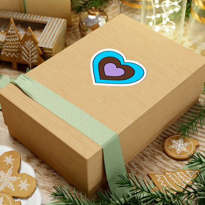 Gift box with a green ribbon on a festive background with cookies and Christmas decorations. Heart-shaped Androsexual pride sticker centered on the box.